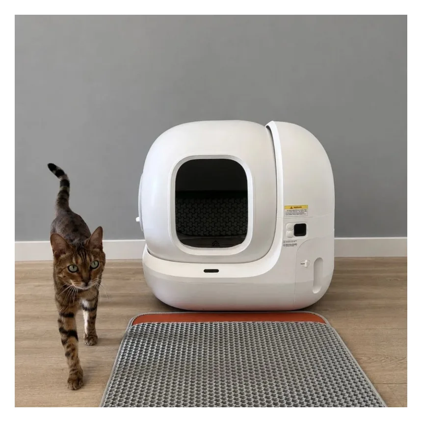 Witte PETKIT Pura Max 2 automatische kattenbak met een kat en een antislipmat ervoor