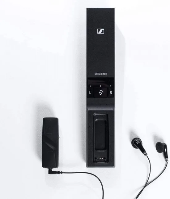 Sennheiser FLEX 5000 zender met laadstation, clip-ontvanger en oordopjes op een witte achtergrond
